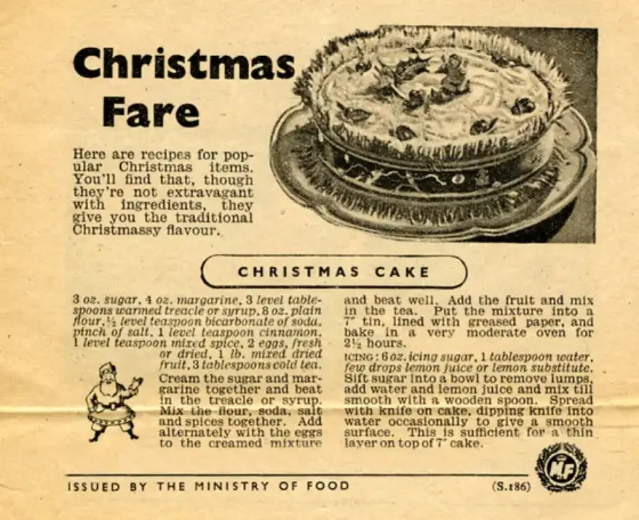 A vintage recipe page titled "Christmas Fare" features a detailed illustration of a decorated Christmas cake. The page includes a recipe for Christmas cake and is issued by the Ministry of Food.