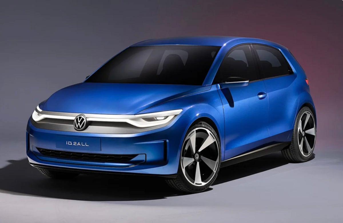 A sleek blue Volkswagen ID.2all electric hatchback is positioned in a studio setting with a gradient background, showcasing its modern design, LED headlights, and distinctive alloy wheels.