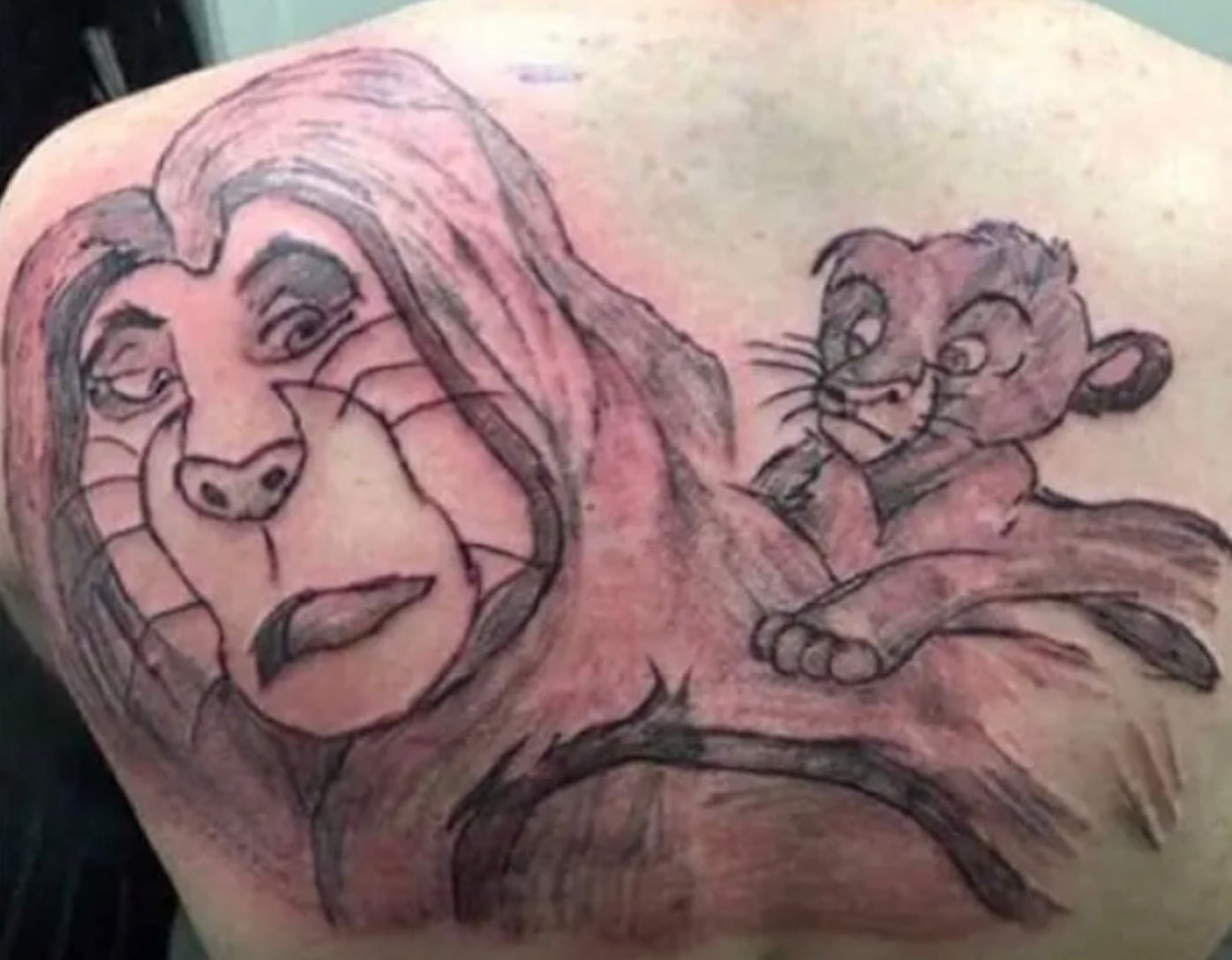 A tattoo on someone's back depicts two poorly drawn cartoon lions, one large with a sad expression and one smaller lion cub clinging to its back. The style appears rough and unfinished.
