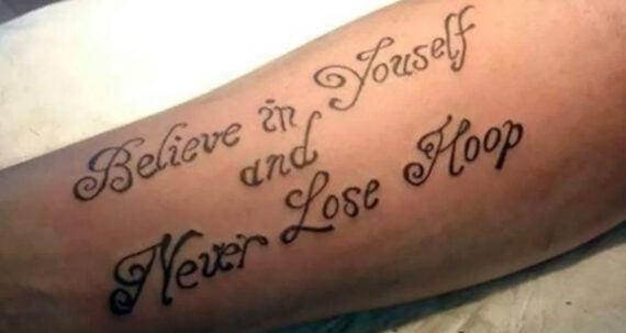 A tattoo on an arm with decorative script text that says, "Believe in Youself and Never Lose Hoap," containing spelling errors for "yourself" and "hope.