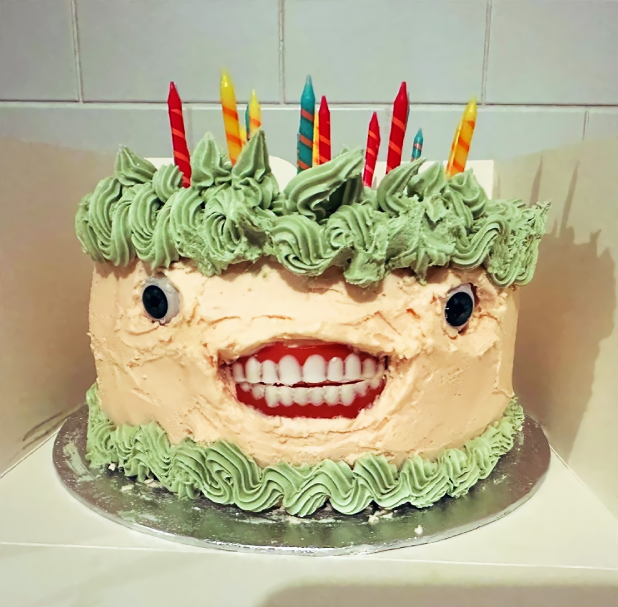 A cake with a face and candles on it
