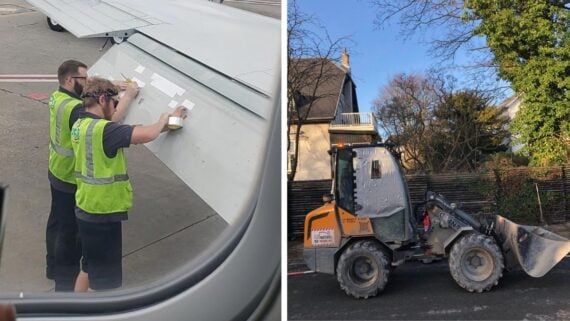 Two workers in safety vests tape the wing of an airplane on a runway. Next to it, a small bulldozer with its cab windows covered in plastic and tape is parked near a house, surrounded by trees.