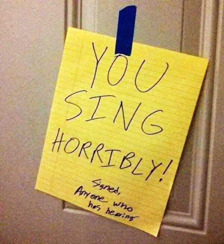 A yellow lined paper taped to a door reads, "YOU SING HORRIBLY!" with "Signed, Anyone who has hearing" written underneath in smaller letters.