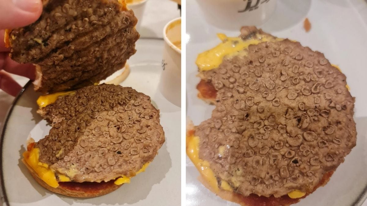 A close-up of a hamburger with the top bun removed, showing a dry, overcooked beef patty, partially eaten, with visible cheese and a bit of sauce on a plate.