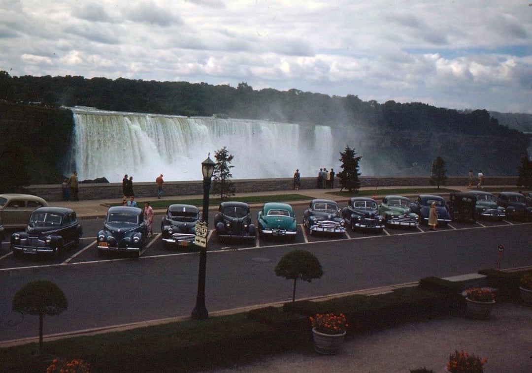 A group of cars parked in front of a waterfall