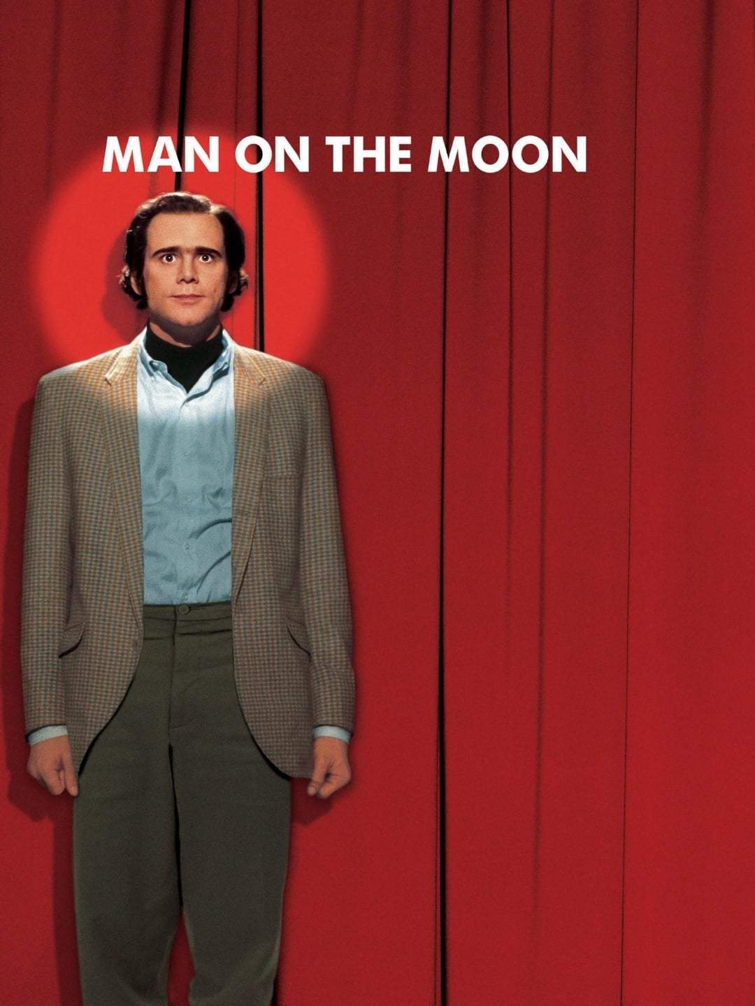 A man in a checkered blazer and blue shirt stands in front of closed red curtains, illuminated by a spotlight, with the text "MAN ON THE MOON" above his head.