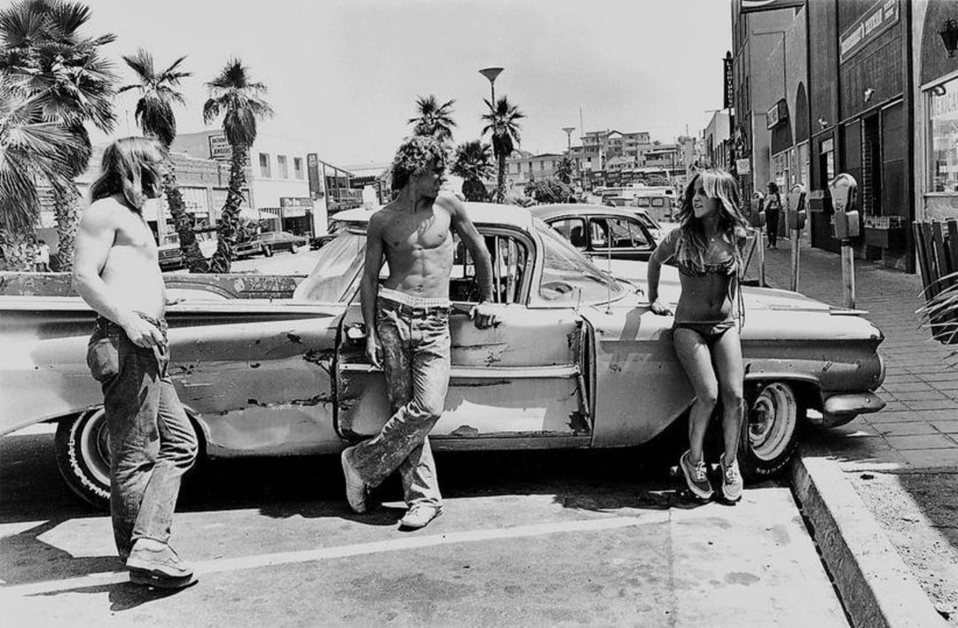 A group of people standing next to a car