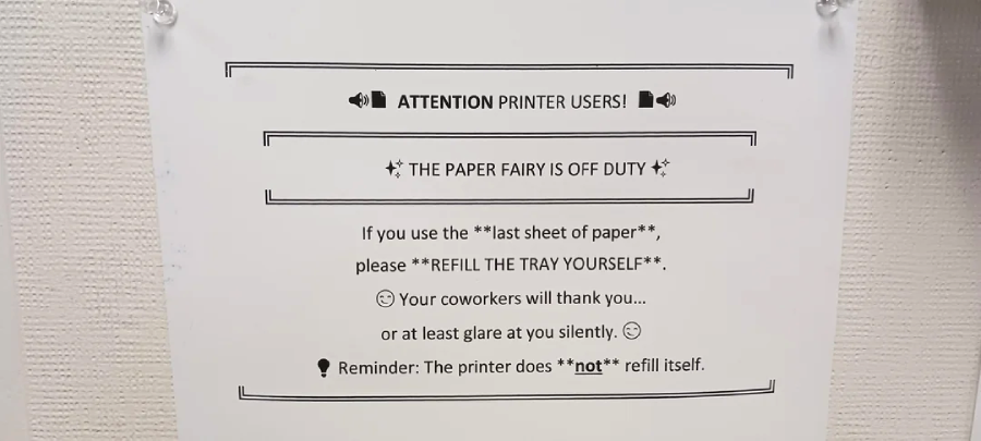 A printed sign on a wall reads: "ATTENTION PRINTER USERS! THE PAPER FAIRY IS OFF DUTY. If you use the last sheet of paper, REFILL THE TRAY YOURSELF. Reminder: The printer does not refill itself.