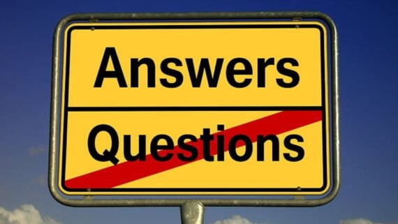 A yellow road sign with the words "Answers" above a black line and "Questions" below it, with a red slash crossing out "Questions," against a blue sky background.