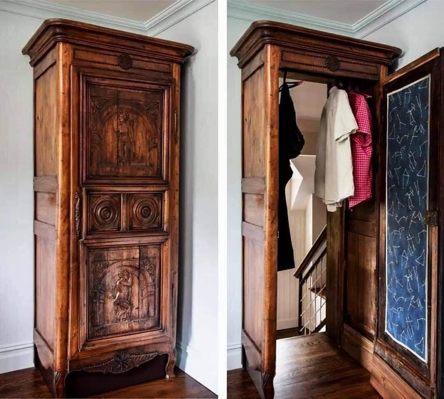 A wooden wardrobe stands closed on the left; on the right, its door opens to reveal a hidden passageway and coats hanging inside. The wardrobe features ornate carvings and an inner panel with a constellation pattern.