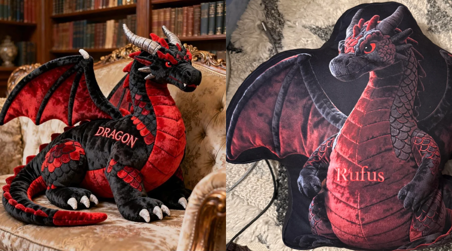 A plush red and black dragon toy with the word "DRAGON" embroidered on its side sits on a sofa, next to a dragon-shaped pillow with "Rufus" embroidered, both in a cozy, book-filled room.