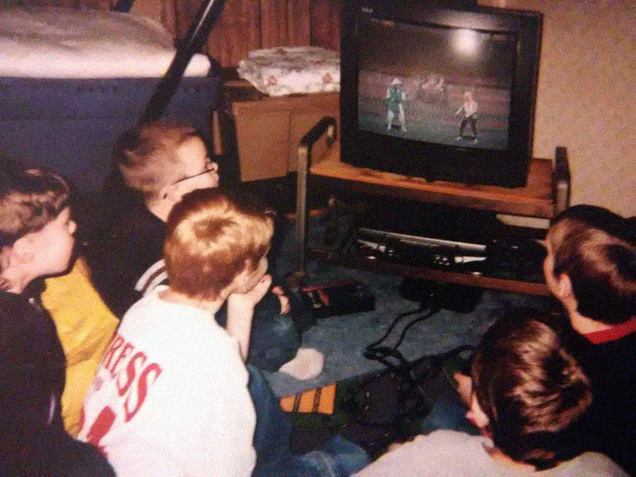 Five kids sit on the floor, closely watching and playing a fighting video game on a CRT television. The TV is on a wooden stand, and there’s a game console and controllers beneath it. The scene appears nostalgic and retro.