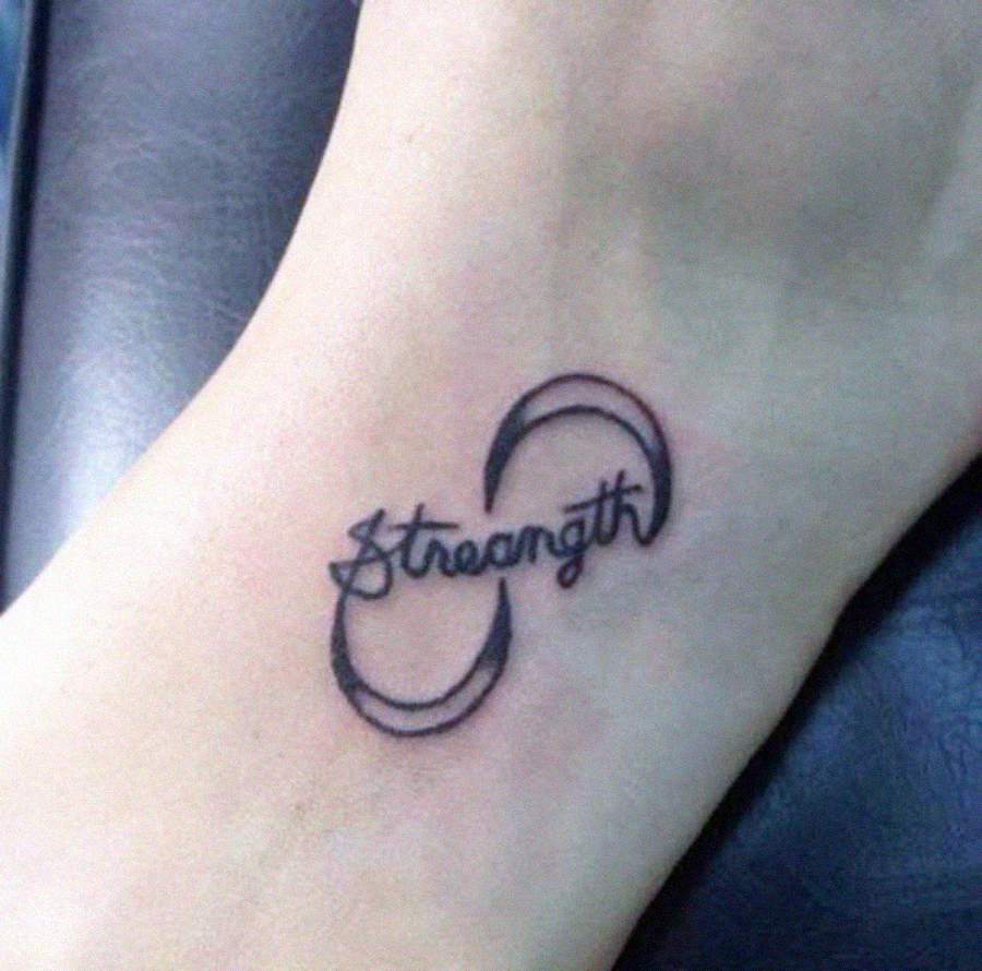 A tattoo on skin showing the word "Strength" in cursive font, partially enclosed by two crescent shapes forming an incomplete circle around the text.