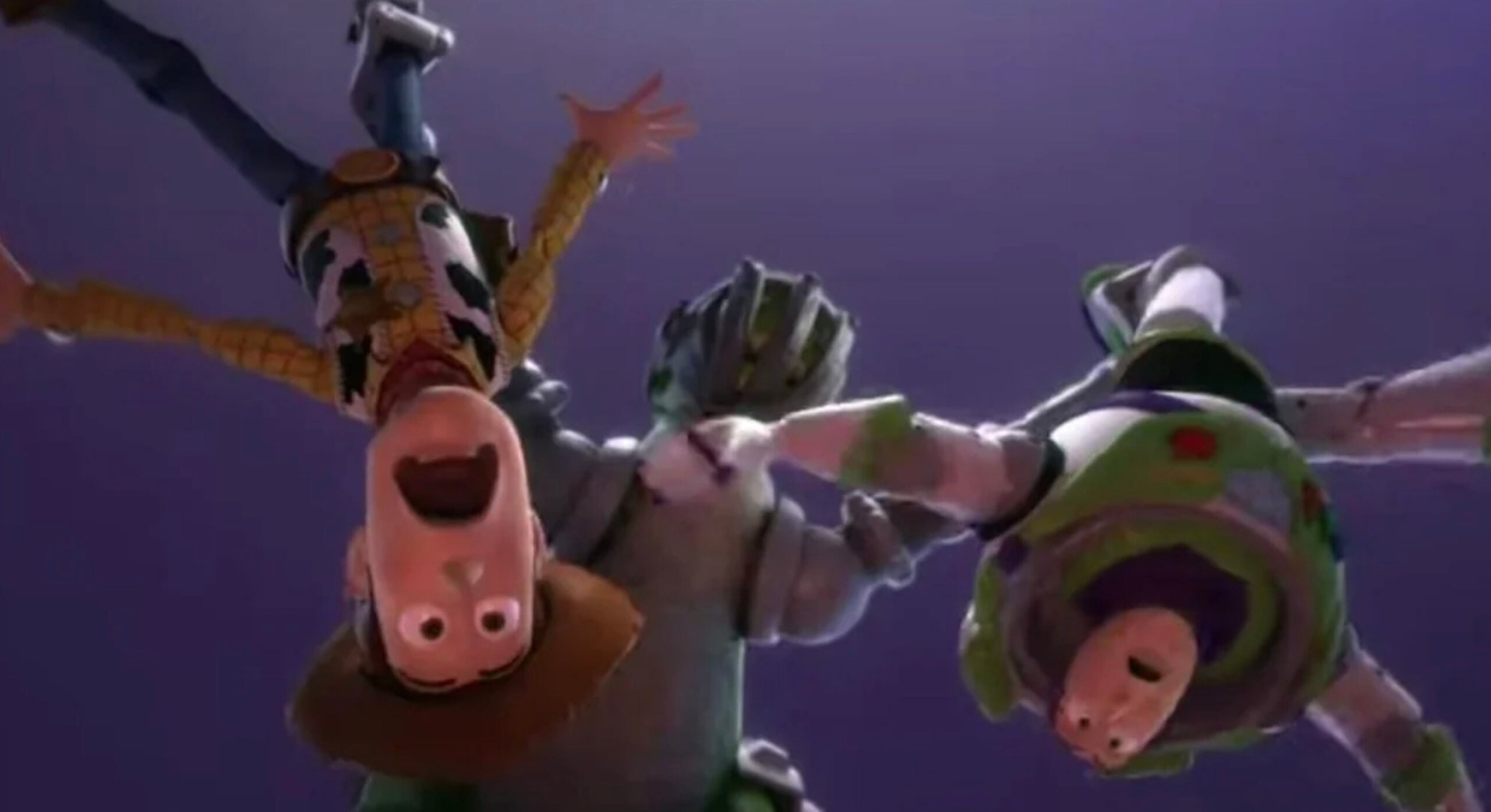 Woody and Buzz Lightyear, animated toy characters from Toy Story, are shown upside down in mid-air, holding hands and smiling with excited expressions against a purple background.