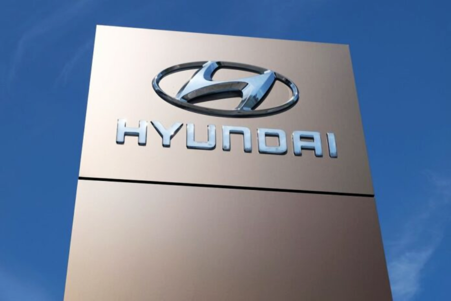 A tall sign with the Hyundai logo and the word "HYUNDAI" in metallic letters stands against a clear blue sky.
