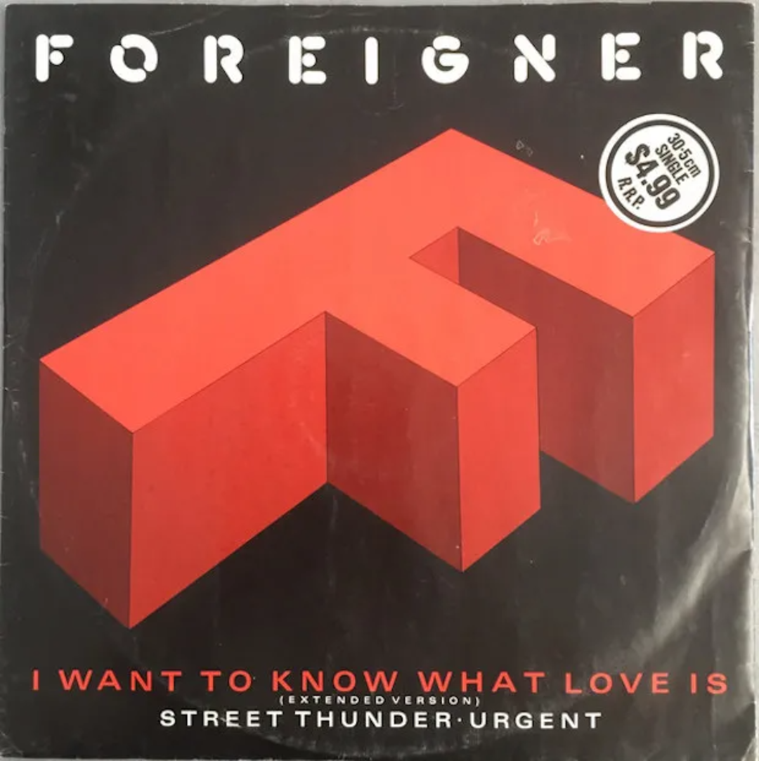 Album cover for Foreigner’s "I Want to Know What Love Is" single, featuring a bold red geometric "F" shape on a black background, with a price sticker and song titles in white and red text.