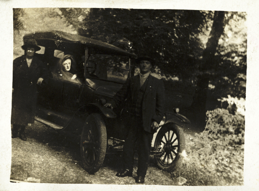 A man and woman standing next to a car