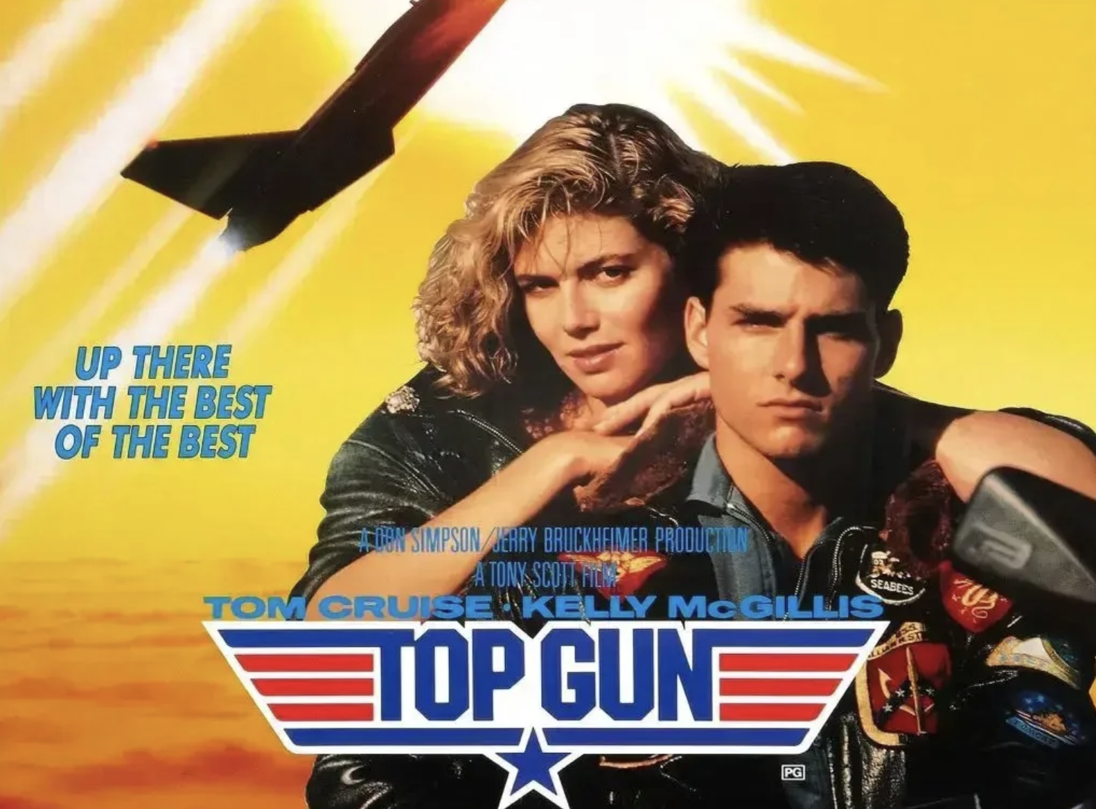 Movie poster for "Top Gun" shows a woman with curly blonde hair leaning on a man in a pilot jacket, with bold yellow and orange background, text reading "UP THERE WITH THE BEST OF THE BEST" and the "Top Gun" title below.