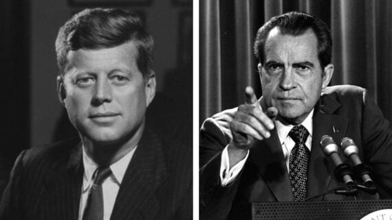 Side-by-side black-and-white portraits of two men in suits; the man on the left faces forward with a neutral expression, while the man on the right points and speaks into microphones.