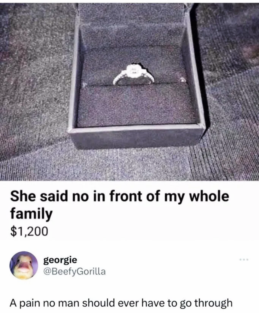A diamond engagement ring in an open black box. Text above reads, "She said no in front of my whole family $1,200." Below, a tweet says, "A pain no man should ever have to go through.