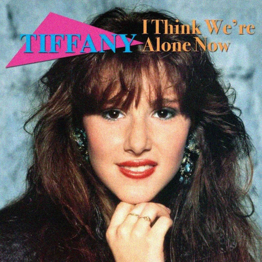 Close-up of a young woman with wavy brown hair and bright earrings, smiling at the camera. Text reads “TIFFANY” and “I Think We’re Alone Now” in colorful, bold fonts at the top.