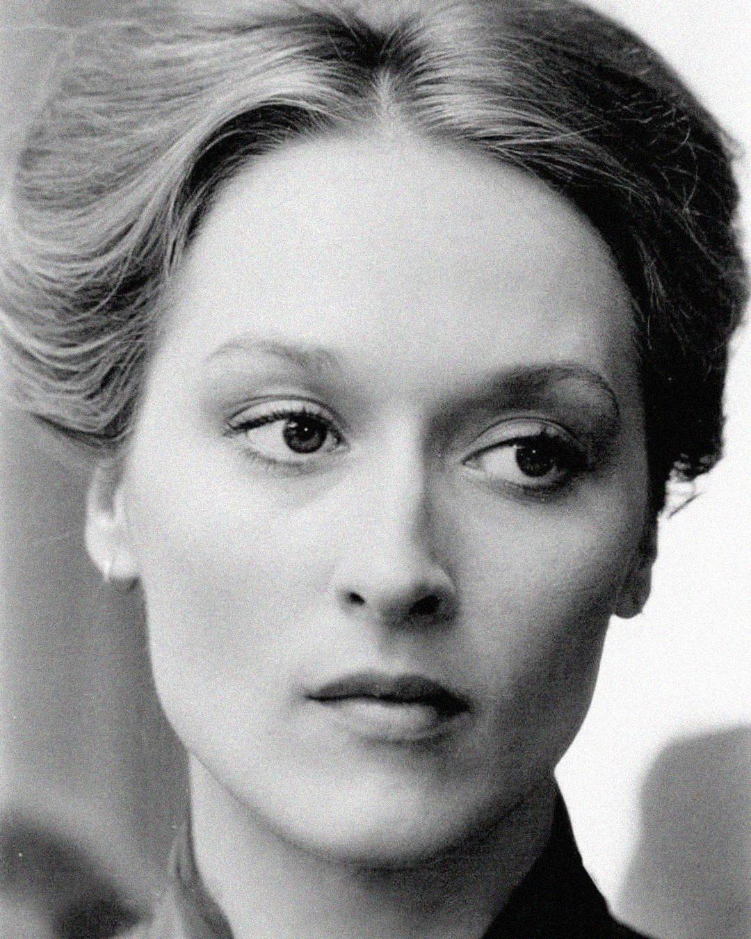 A black-and-white close-up portrait of a woman with light skin and neatly styled hair, gazing slightly to the side with a calm, contemplative expression.