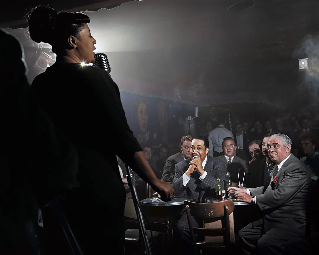 A jazz singer performs on stage in a dimly lit club, holding a microphone. The audience, dressed in suits, watches intently from their tables, drinks on the table, as smoke drifts through the air.