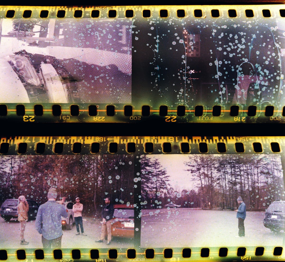 Scanned film negatives showing four photos. The upper two have damage and are hard to see; the lower two show a group of people standing in a parking lot with trees and cars in the background.