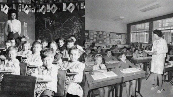 Vintage classroom with children sitting at desks in a strict school environment