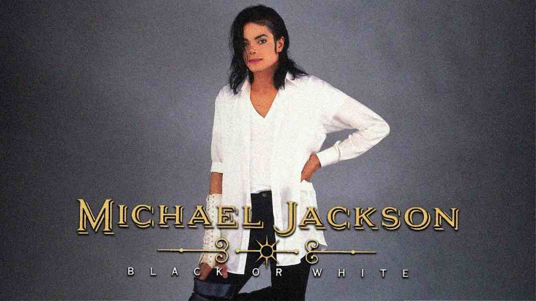 Michael Jackson stands with one hand on his hip, wearing a white shirt and black pants, against a gray background. The text reads "Michael Jackson Black or White" in gold and white letters.