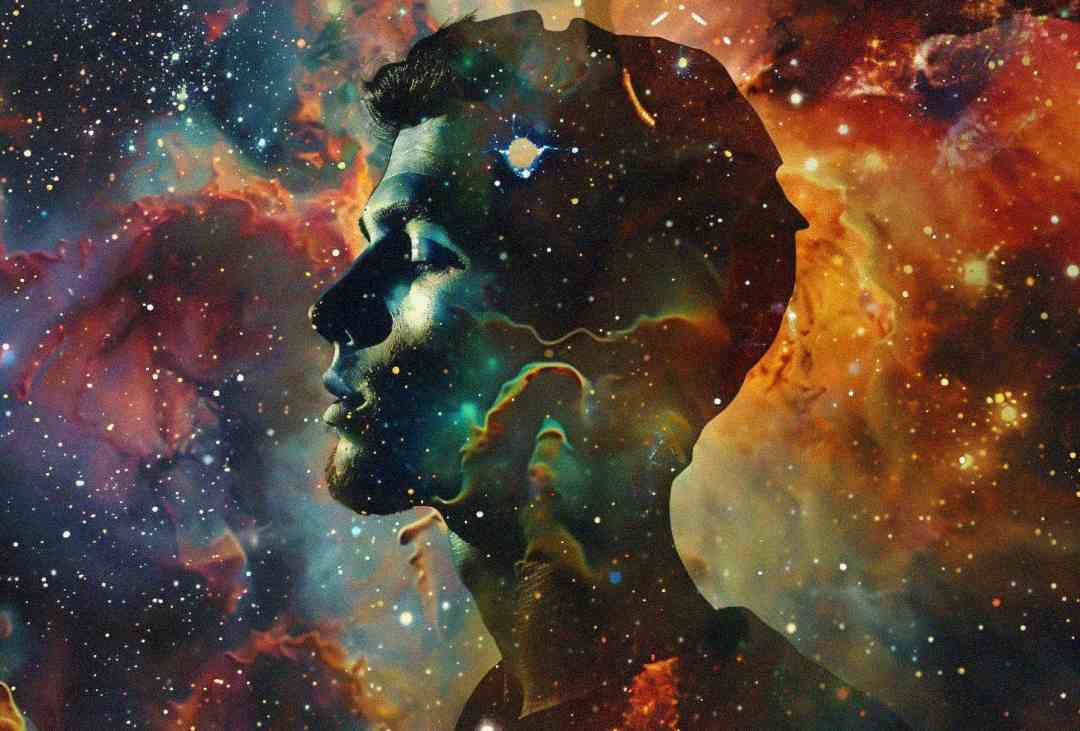 A side profile silhouette of a man's face blends seamlessly with a vibrant, colorful cosmic scene of stars and nebulae, creating an effect as if the universe is within his mind.