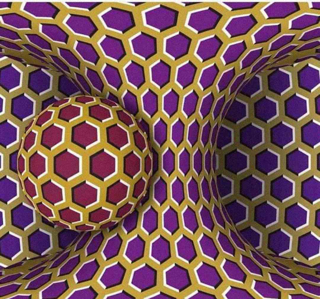 A colorful optical illusion featuring a pattern of yellow, purple, and white hexagons. The design warps inward at the center, creating a tunnel effect, with a matching patterned sphere appearing to float on the left side.