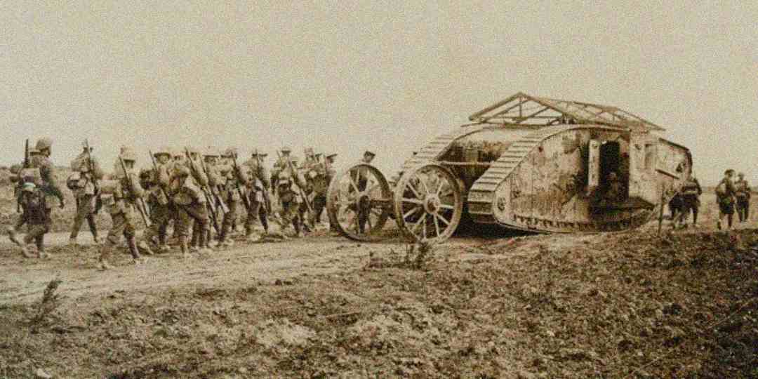 A group of World War I soldiers march beside a large early tank on a dirt battlefield, with the scene captured in sepia tones.