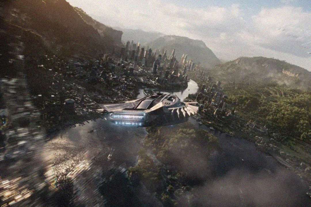 A futuristic city with tall buildings is nestled in a lush, green valley with mountains in the distance. In the center, a large, sleek, high-tech structure sits by a river under a partly cloudy sky.