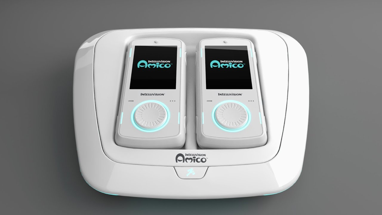 A white Intellivision Amico game console with two matching handheld controllers docked on top, each displaying the Amico logo on their screens, against a gray background.