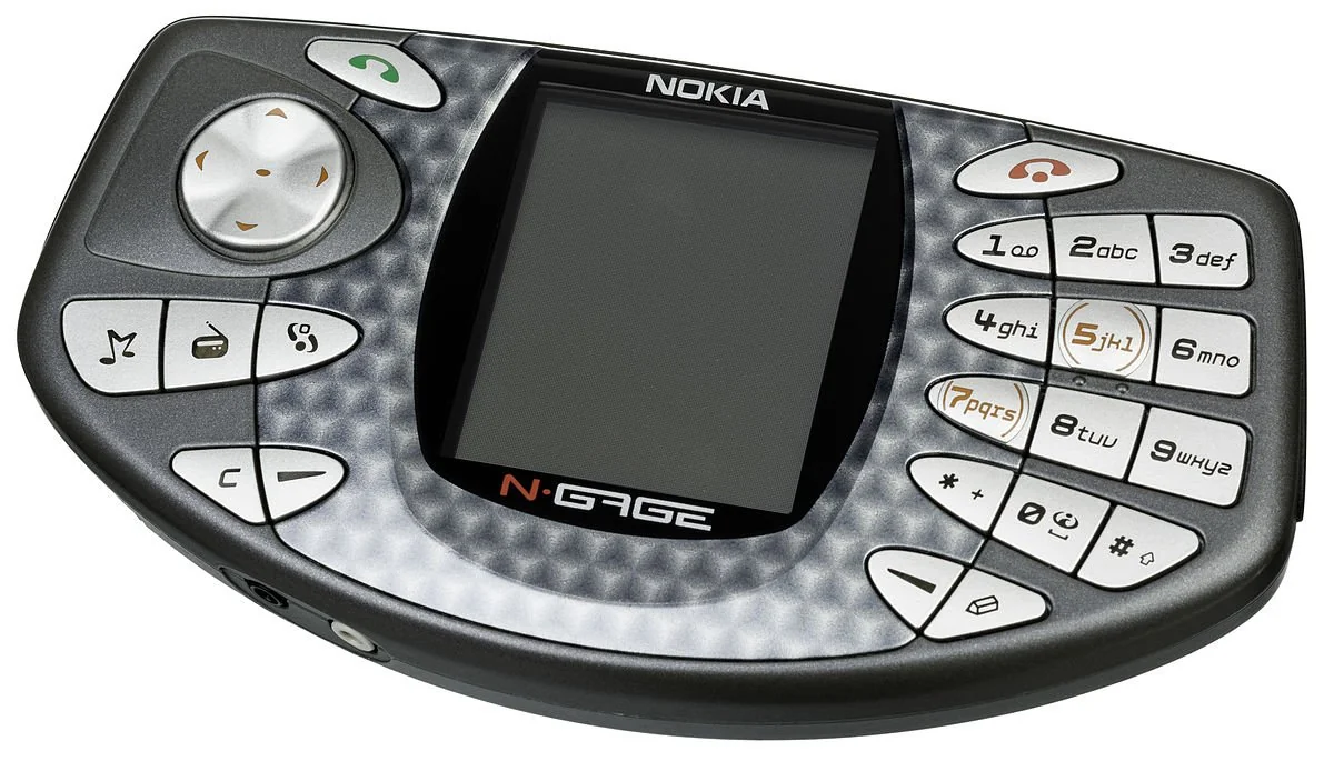 A Nokia N-Gage handheld device featuring a screen in the center, a directional pad on the left, and a numeric keypad on the right, designed for gaming and mobile phone use.