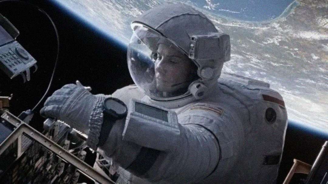 An astronaut in a spacesuit works on equipment outside a spacecraft with Earth visible in the background.
