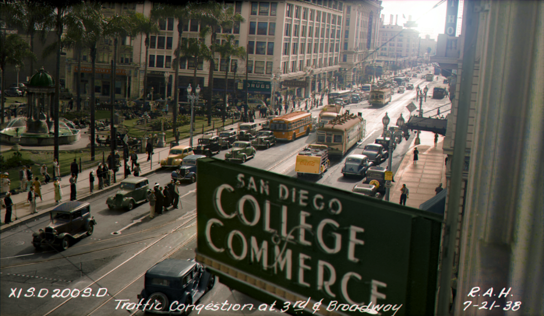 Historic street scene in San Diego, 1938, showing traffic congestion with vintage cars, streetcars, pedestrians, palm trees, and a large “College of Commerce” sign in the foreground.