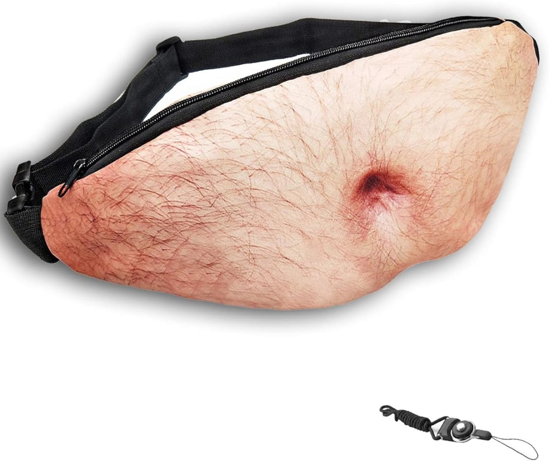 A fanny pack designed to look like a hairy belly with a belly button; it has a zipper on top and an adjustable black strap. A small black keychain is displayed in the corner.