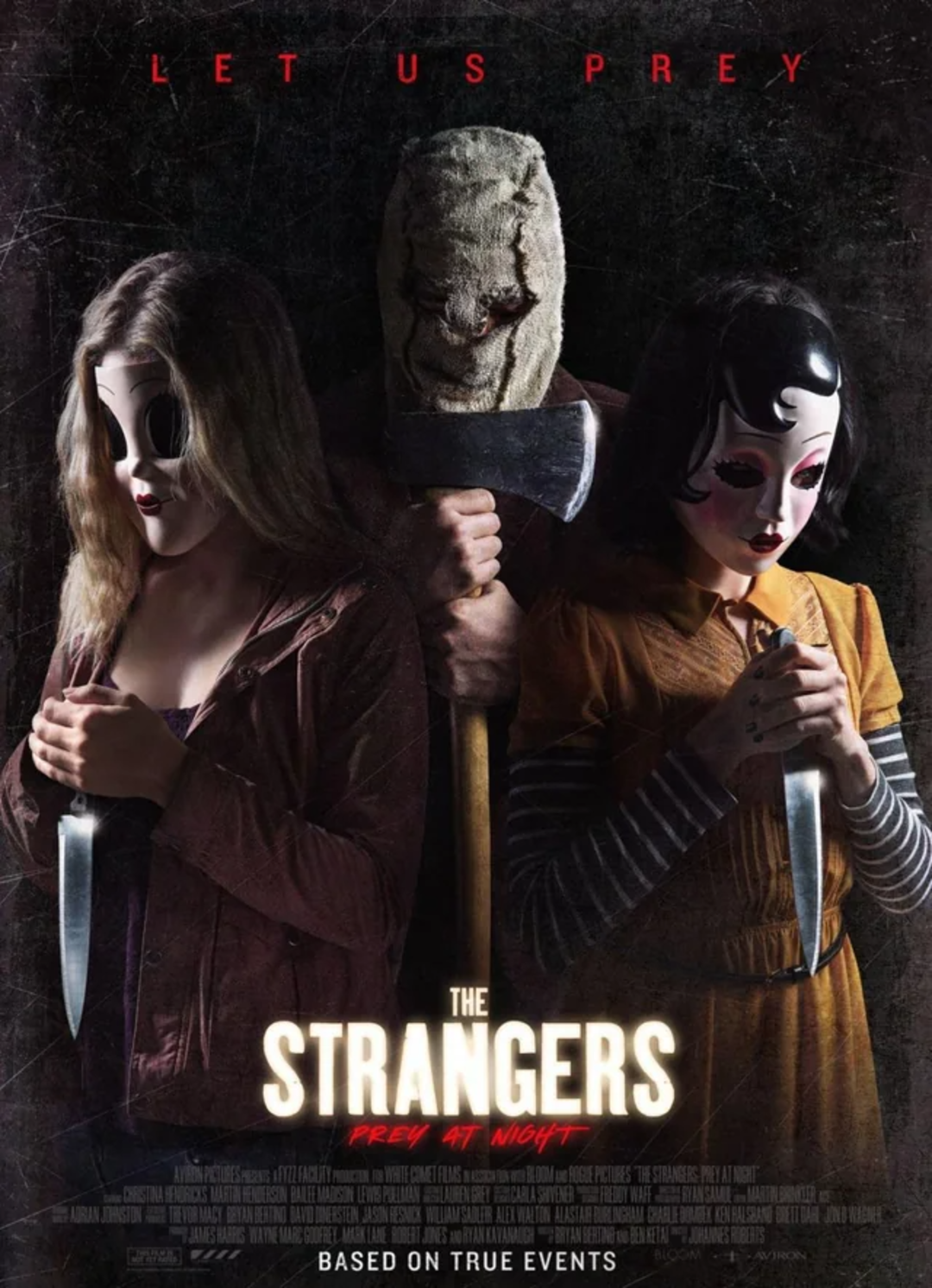 Three masked figures in eerie costumes, two holding large knives and one holding an axe, stand together against a dark, scratched background. The text reads, "Let Us Prey," and "The Strangers: Prey at Night.