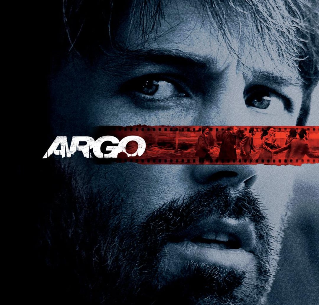 A close-up of a man's face in bluish tones with a serious expression. A red filmstrip runs across his eyes, showing small images of people. The word "ARGO" is bold and white over the filmstrip.