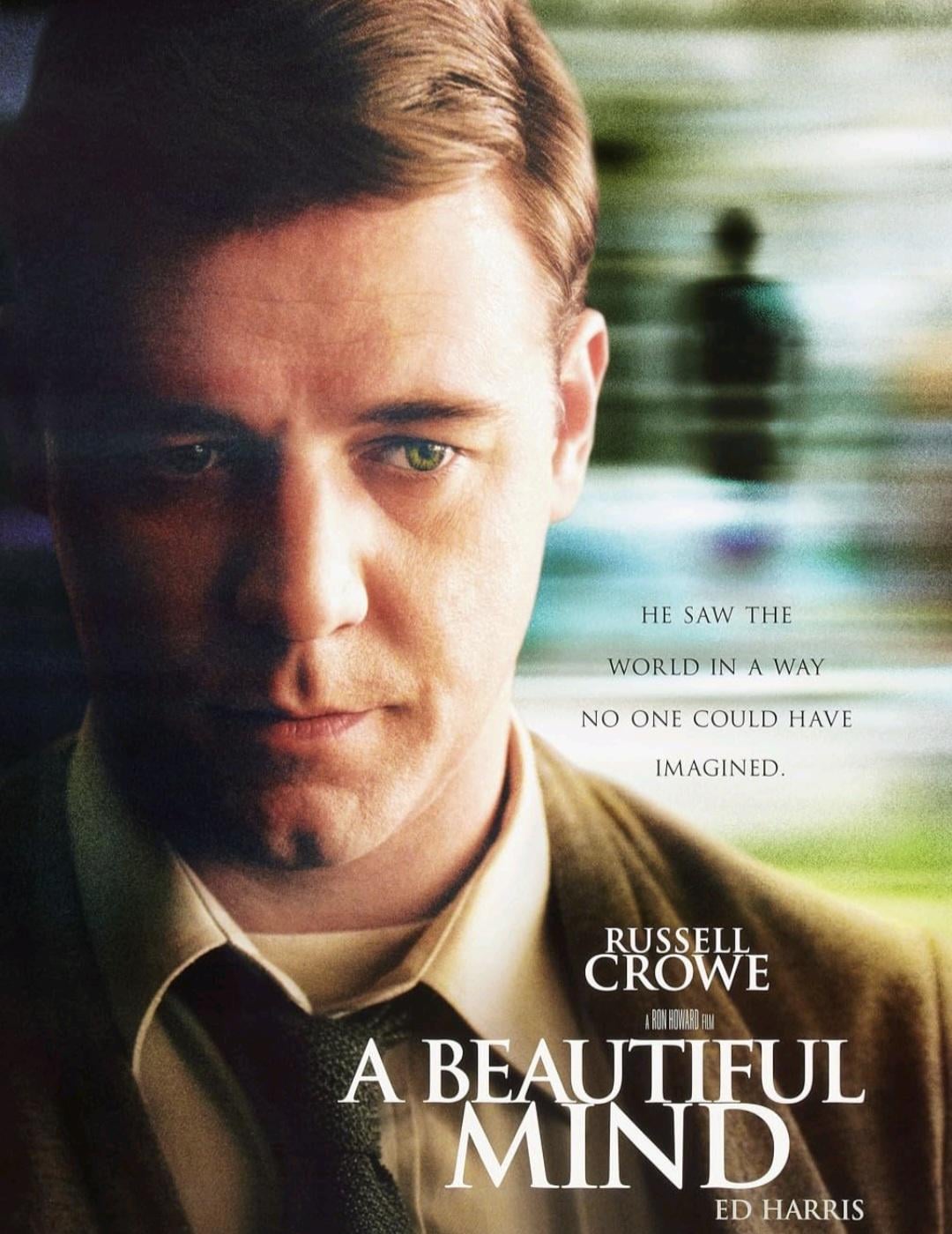 Close-up of a serious man in a suit and tie, with text: “He saw the world in a way no one could have imagined.” Film title: "A Beautiful Mind"; starring Russell Crowe and Ed Harris. Blurred background.