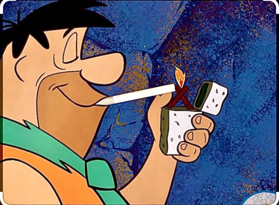 A cartoon character with black hair and an orange outfit is smiling and lighting a cigarette with a large, prehistoric-style lighter against a blue stone background.