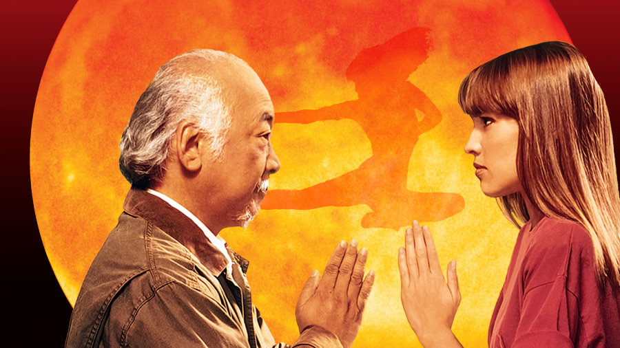 An older man and a young woman face each other with hands raised in a martial arts gesture, with an orange sun and a shadow of a person kicking in the background.
