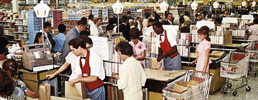 A busy supermarket scene from the past shows cashiers in red vests and shoppers at checkout lines with grocery carts, paper bags, and vintage cash registers.