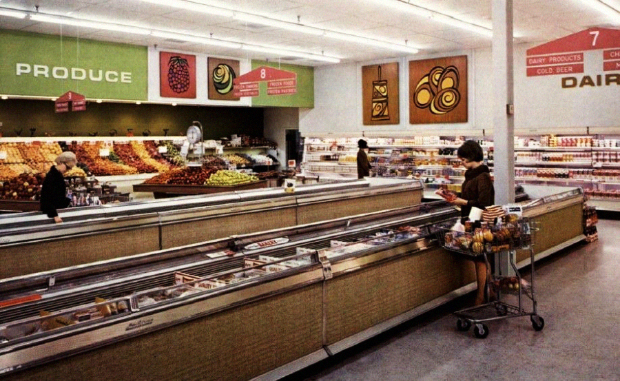 A vintage supermarket scene with shoppers browsing aisles. Fresh produce is displayed on the left, frozen goods in open freezers in the center, and dairy products line the back wall. Signs and colorful wall art decorate the store.