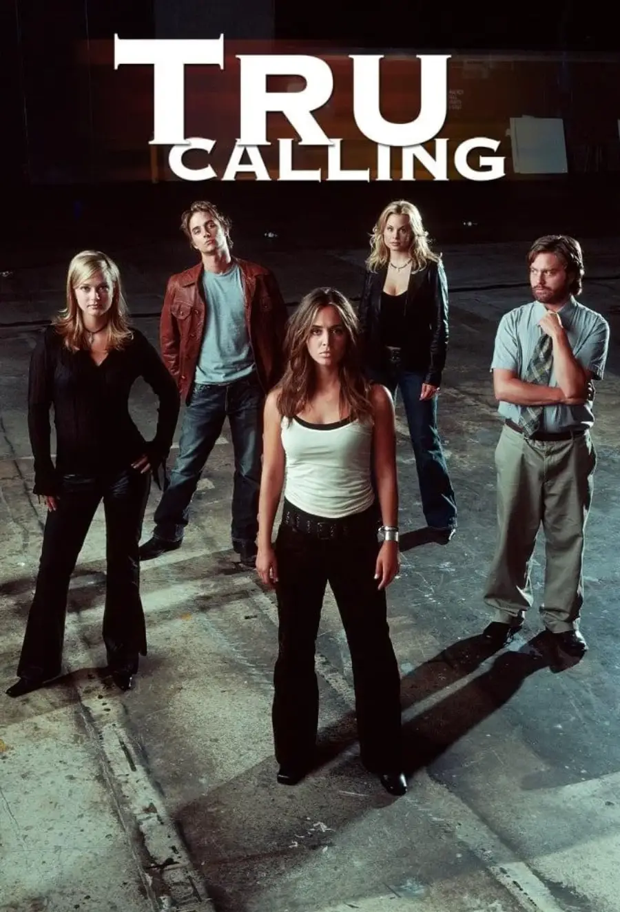 Five people stand on a dimly lit concrete floor under the title "Tru Calling." A woman in a white tank top stands front and center, with four others in casual clothes behind her, all looking toward the camera.