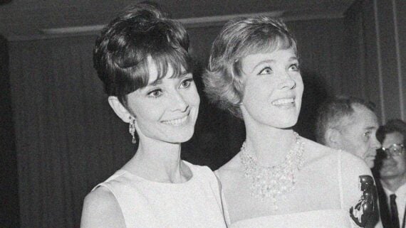 Audrey Hepburn and Julie Andrews smiling together at a glamorous Hollywood event in the 1960s