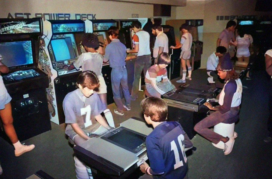 A group of teenagers in retro clothing play various classic arcade games in a lively, vintage arcade. Some are standing at upright machines while others sit at tabletop consoles, all focused on their games.