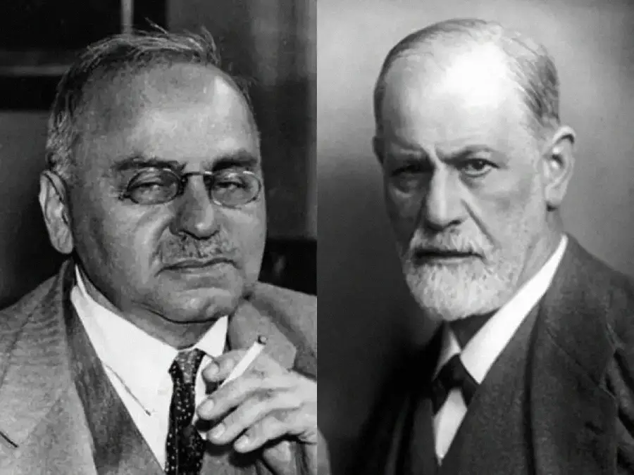Two black-and-white portraits of older men in suits, both with glasses and mustaches; the man on the left holds a cigarette, while the man on the right has a trimmed white beard and looks directly at the camera.